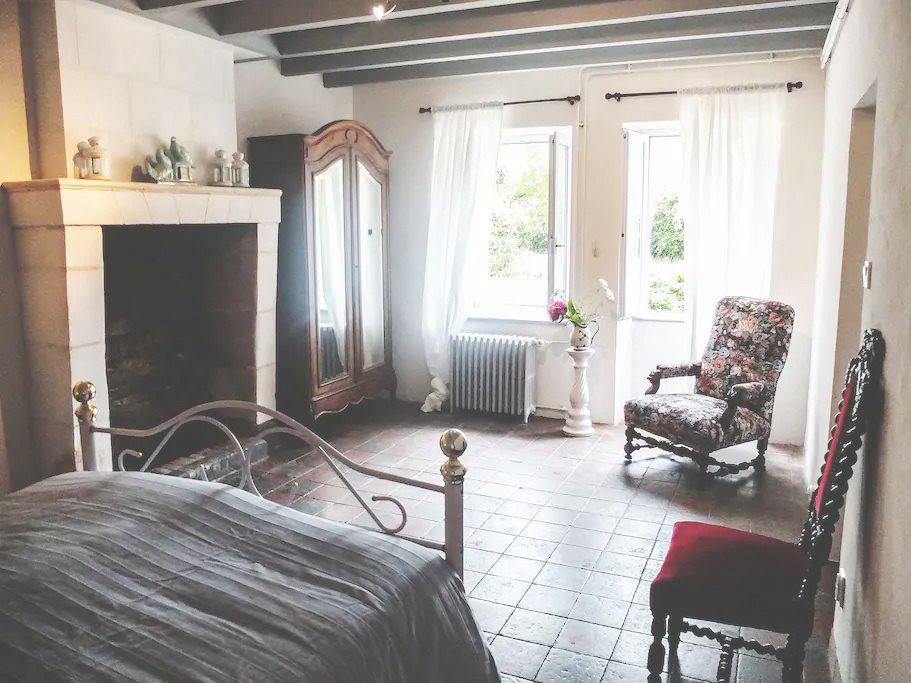 room with bed, fireplace and chairs